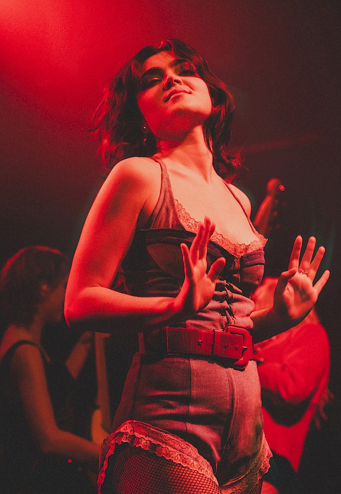 Abigail from The Last Dinner Party performing in the denim playsuit